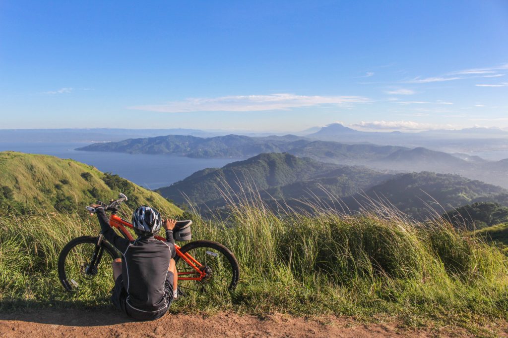 chico admirando un paisaje de montaña con su bicicleta mtb o de montaña