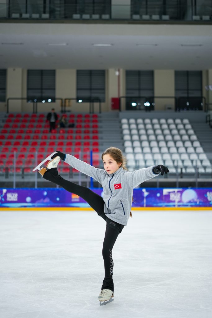 niña con patines sobre hielo. 