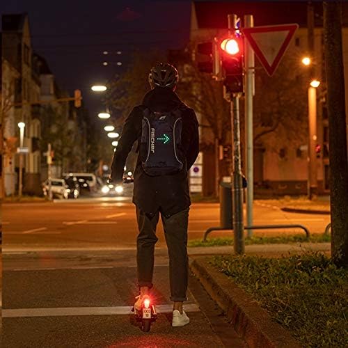 mochila Fischer con función intermitente en la espalda de una persona montada en un patinete eléctrico
